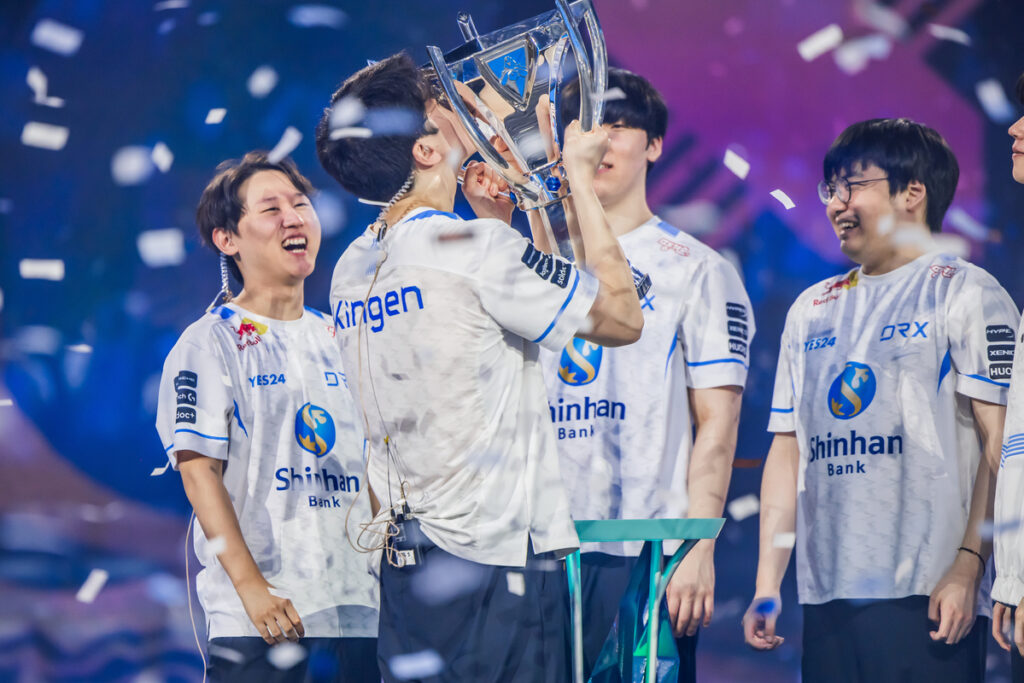 Image shows DRX players celebrating their Worlds 2022 victory with a trophy.