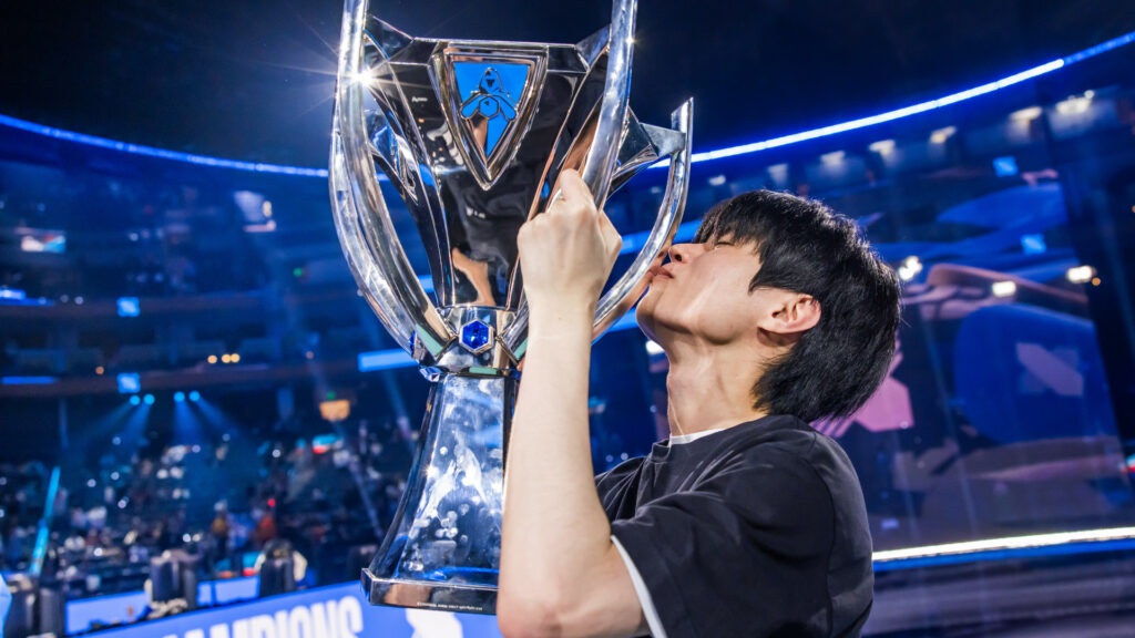 Images shows DRX player Deft kissing a large trophy after winning Worlds 2022
